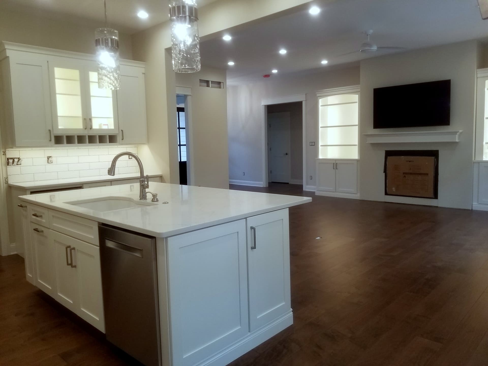 White kitchen with a quartz island and pendant lights
