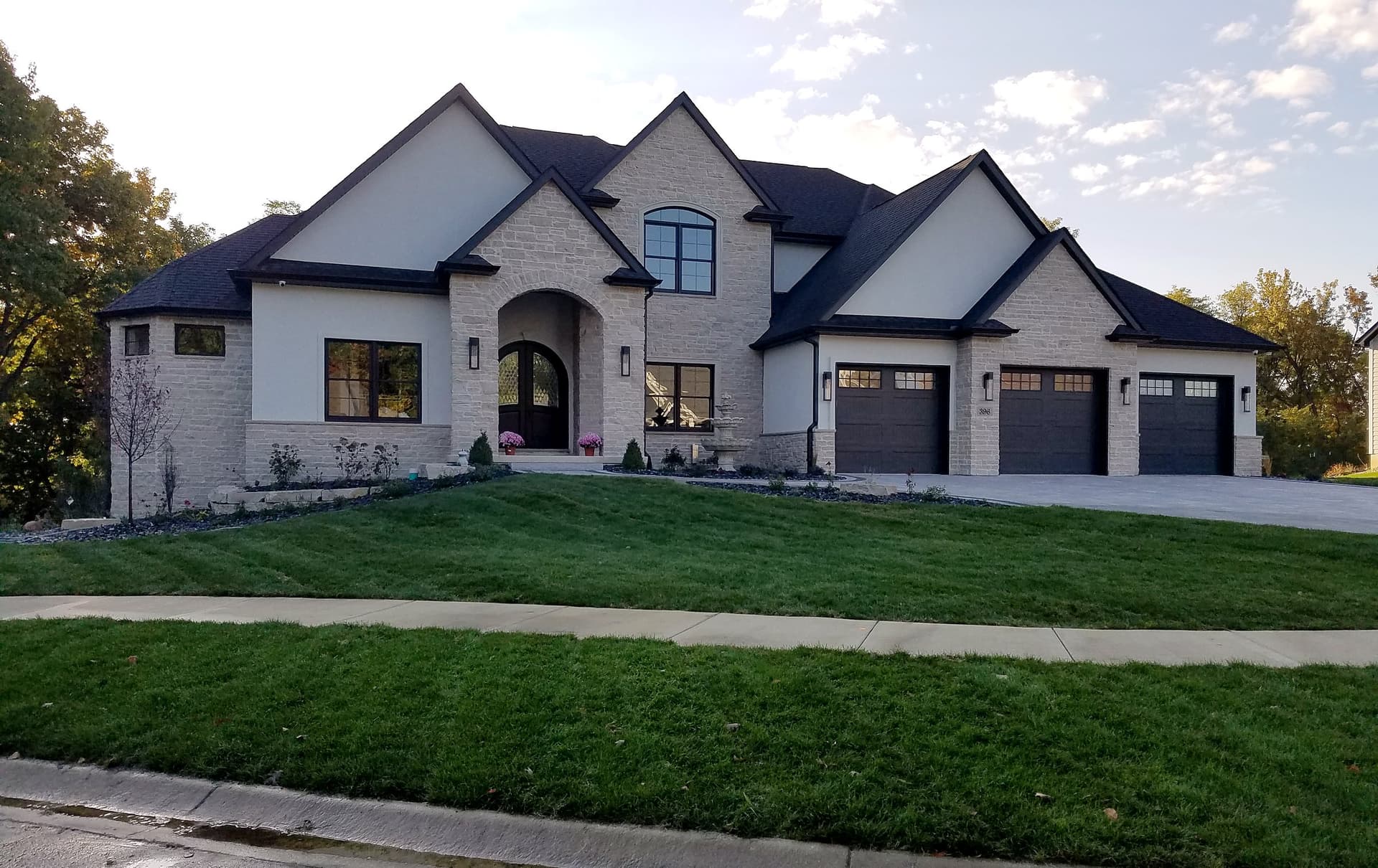 A stone two-story custom home with a three-car garage