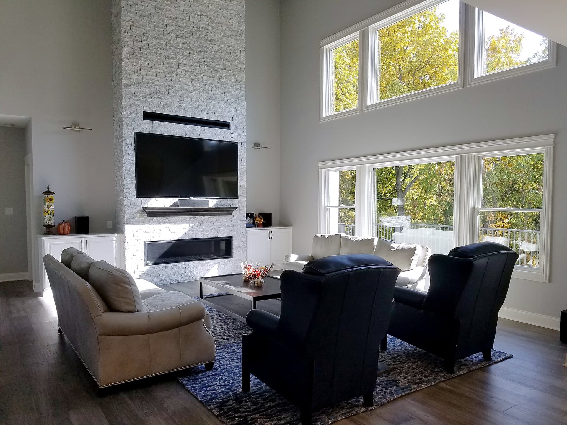 Two-story great room with a stone fireplace wall